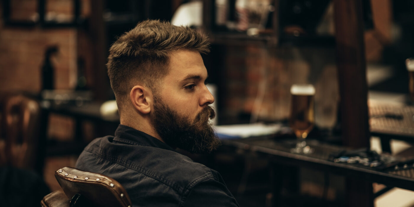 Hombre con barba sentado en una peluquería
