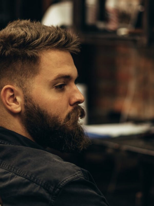 Hombre con barba sentado en una peluquería