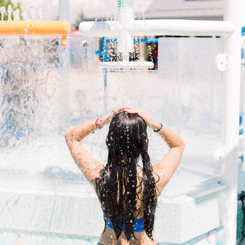 Persona en la piscina enjuagando su prótesis capilar